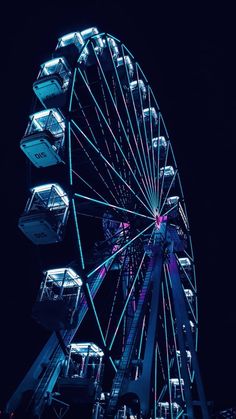 a ferris wheel lit up at night with the lights on it's sides and windows