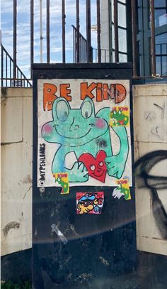 a sign that is on the side of a building with graffiti writing be kind to it