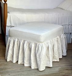 a bed with a white bedspread and a wooden headboard next to it