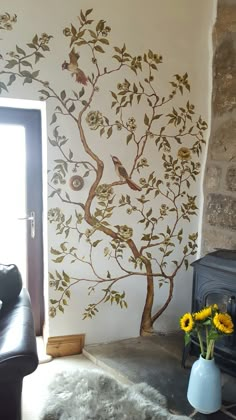 a living room with a tree painted on the wall