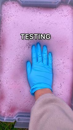 a person in blue gloves is standing next to a pink foam tray with the words testing written on it