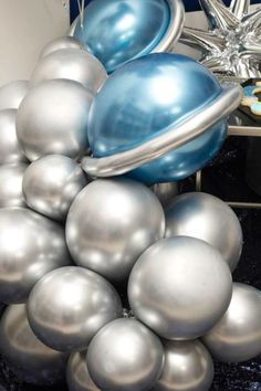 silver and blue balloons are stacked on top of each other