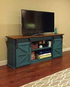 a flat screen tv sitting on top of a wooden entertainment center in a living room