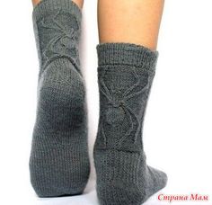 the legs and ankles of a woman wearing gray socks with cabled design on them