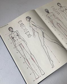 an open book with drawings of female mannequins