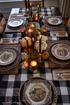 the table is set with plates and candles