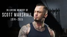 a man with tattoos standing in front of a black and white background that says, in loving memory of scott marshall, 1974 - 2013