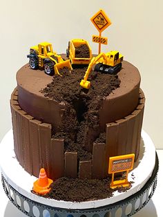 there is a cake that has construction trucks on the top and dirt in the middle