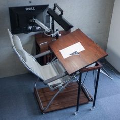 a desk with a computer monitor on top of it and a chair underneath the desk