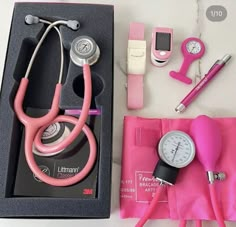 a pink stethoscope and other medical supplies on a white table with a black box