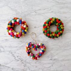 three pieces of colorful beaded jewelry sitting on a marble counter top next to each other