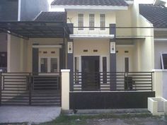 a house that is painted white and has black railings on the front, and two story houses in the background