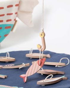 wooden toys are hanging from strings on a table