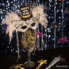 a masquerade mask and other decorations on a table in front of a new year's background