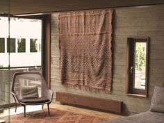 a living room with a couch, chair and rug in front of a large window