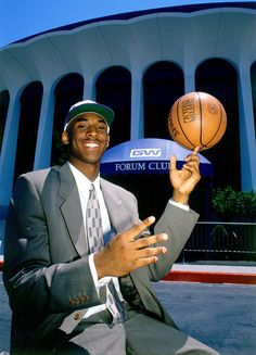 a man in a suit and tie holding a basketball