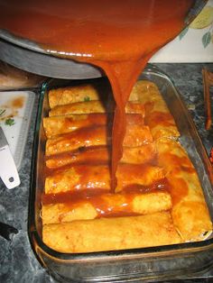 someone pouring sauce on some food in a pan