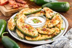 an eggplant and cheese appetizer on a plate next to green peppers