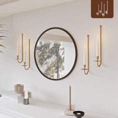 there is a mirror and candles on the mantle in this room with white walls,