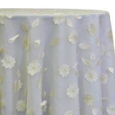 a table cloth with white flowers on it and yellow trim around the edges, in front of a white background