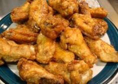 a blue and white plate topped with fried chicken wings