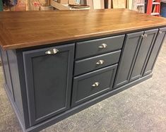 a kitchen island made out of wood with drawers and knobs on the top, in a shop