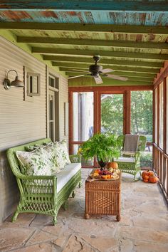 a porch with wicker furniture and plants on it