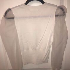 Super Soft, Sheer Sleeve Sweater Top. Gorgeous And Never Worn! I Am A Size Medium In Tops And It Fits Perfect But Can Fit A Large As Well. It’s Not Oversized By Any Means - Except The Sheer Sleeves. You Can Dress Up Or Down! I Have An Example Of The Black Color As Well****** See Pictures. This One I’m Selling Is White Color. Fitted Puff Sleeve Tops For Layering, Fall V-neck Top With Sheer Sleeves, White Casual Top With Mesh Sleeves, Casual White Top With Mesh Sleeves, Casual White Tops With Mesh Sleeves, White Long Sleeve Top With Sheer Sleeves, White Long Sleeve Tops With Sheer Sleeves, White Sheer Sleeve Tops For Fall, Winter Crew Neck Top With Sheer Sleeves