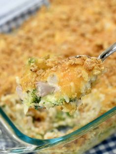 a casserole dish with broccoli and chicken in it is being held by a fork