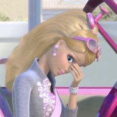 a barbie doll sitting next to a pink bike with her hand on her face and looking at the camera