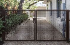 a gated entrance to a house with trees in the background