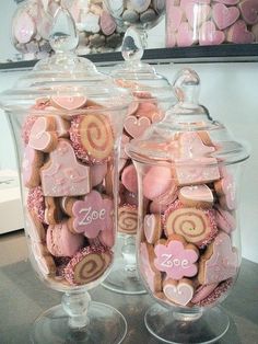 two glass jars filled with pink and white cookies