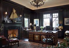 an old fashioned home office with wood paneling and leather furniture, along with a fireplace