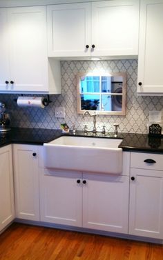 a kitchen with white cabinets and black counter tops is seen in this image from the front view