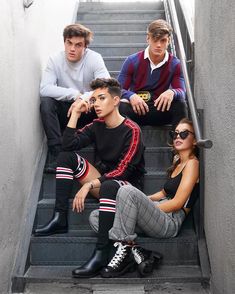 three young people sitting on the stairs with their feet up and one person wearing sunglasses