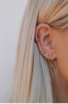 a woman with blonde hair wearing a pair of ear piercings