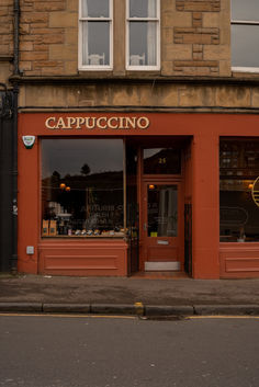 an orange building with the words cappuccino on it's front window