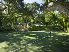 a tennis court surrounded by trees and bushes