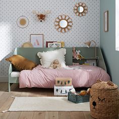 a bed room with a neatly made bed and stuffed animals on the wall behind it