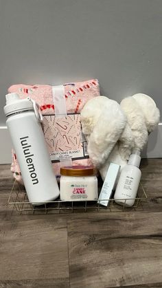 a white teddy bear sitting on top of a wooden floor next to bottles and other items