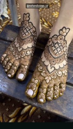 the feet are decorated with henna and intricate designs on their legs, while sitting on a wooden bench