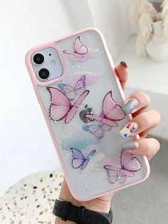 a woman holding up her phone case with butterflies on it