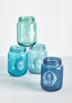 four blue mason jars with anchor and ship symbols on them, all lined up against a white background