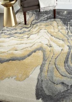 a large rug with an abstract design in grey, yellow and white colors on the floor