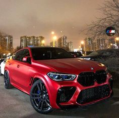 a red bmw suv parked on the street