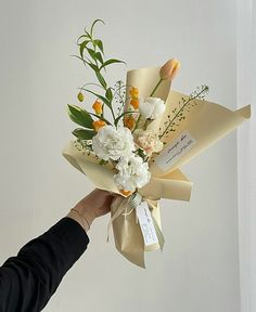 a person holding a bouquet of flowers in their hand