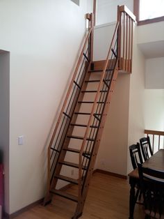 a wooden staircase leading up to a dining room table