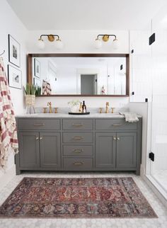 a bathroom with two sinks and a rug on the floor