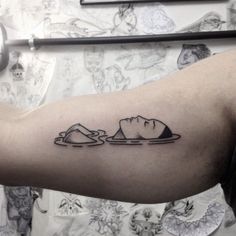 a man's arm with a black and white tattoo on it that has an image of a cat eating food