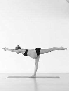 a woman in a black and white photo doing yoga